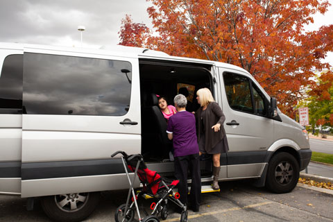 Medical Transport with child in wheelchair in gray van
